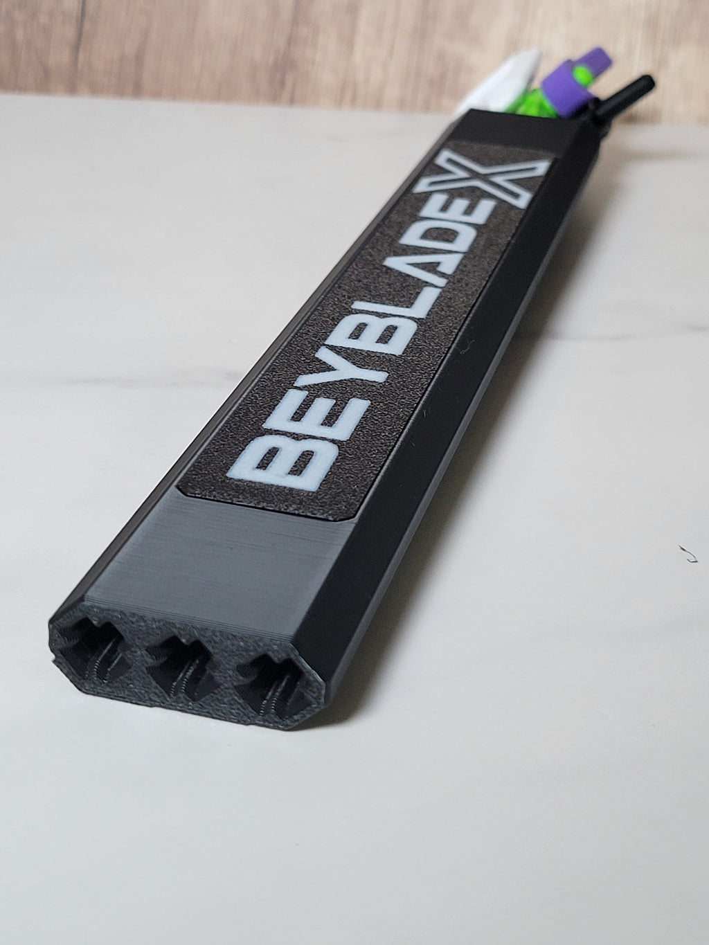 Low angle of the black hex protector showing its white logo panel, three channel openings and loaded rip cords.