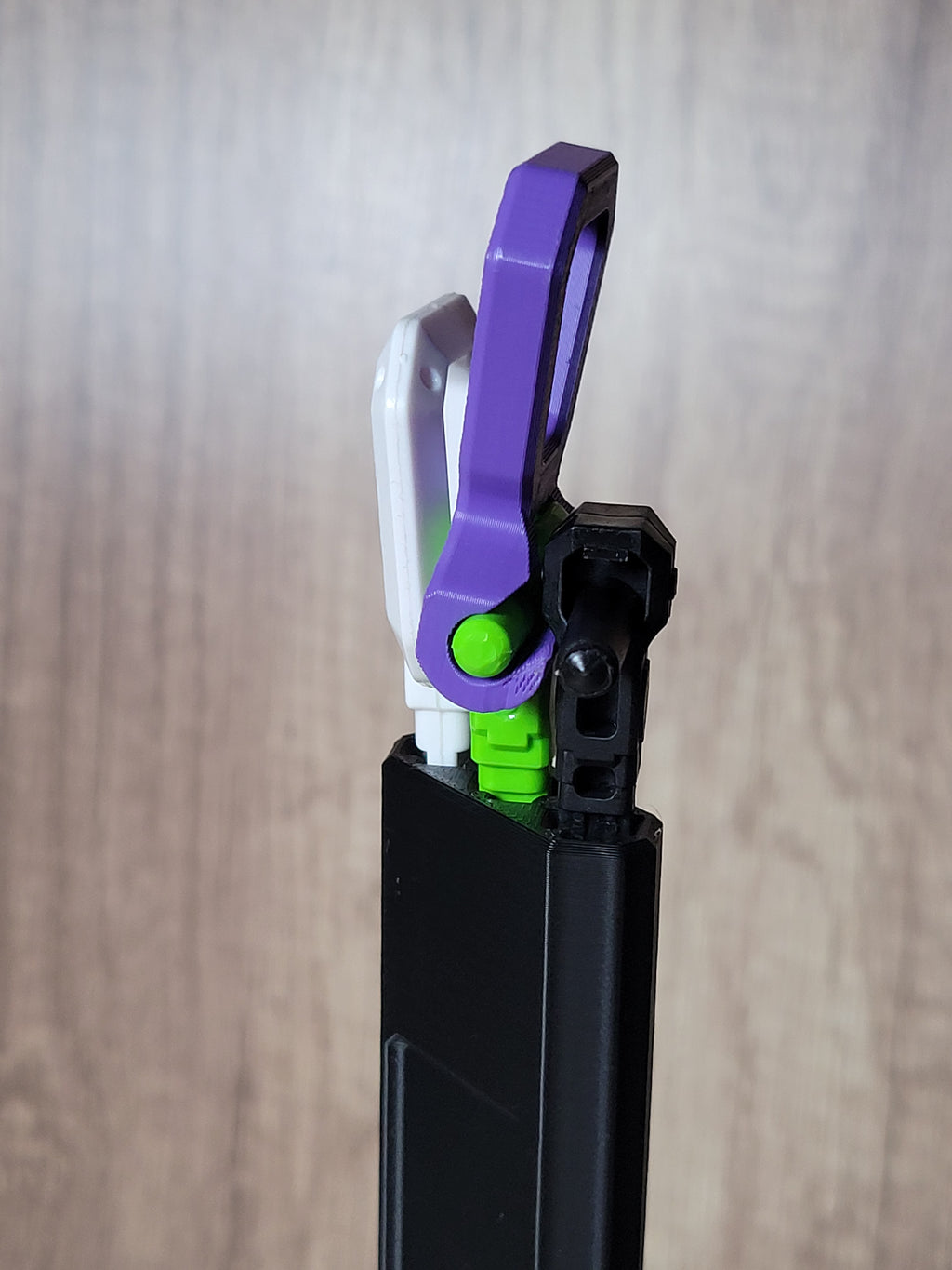 Close-up of white, purple and green rip cord handles loaded into the black protector, showing different handle orientations.
