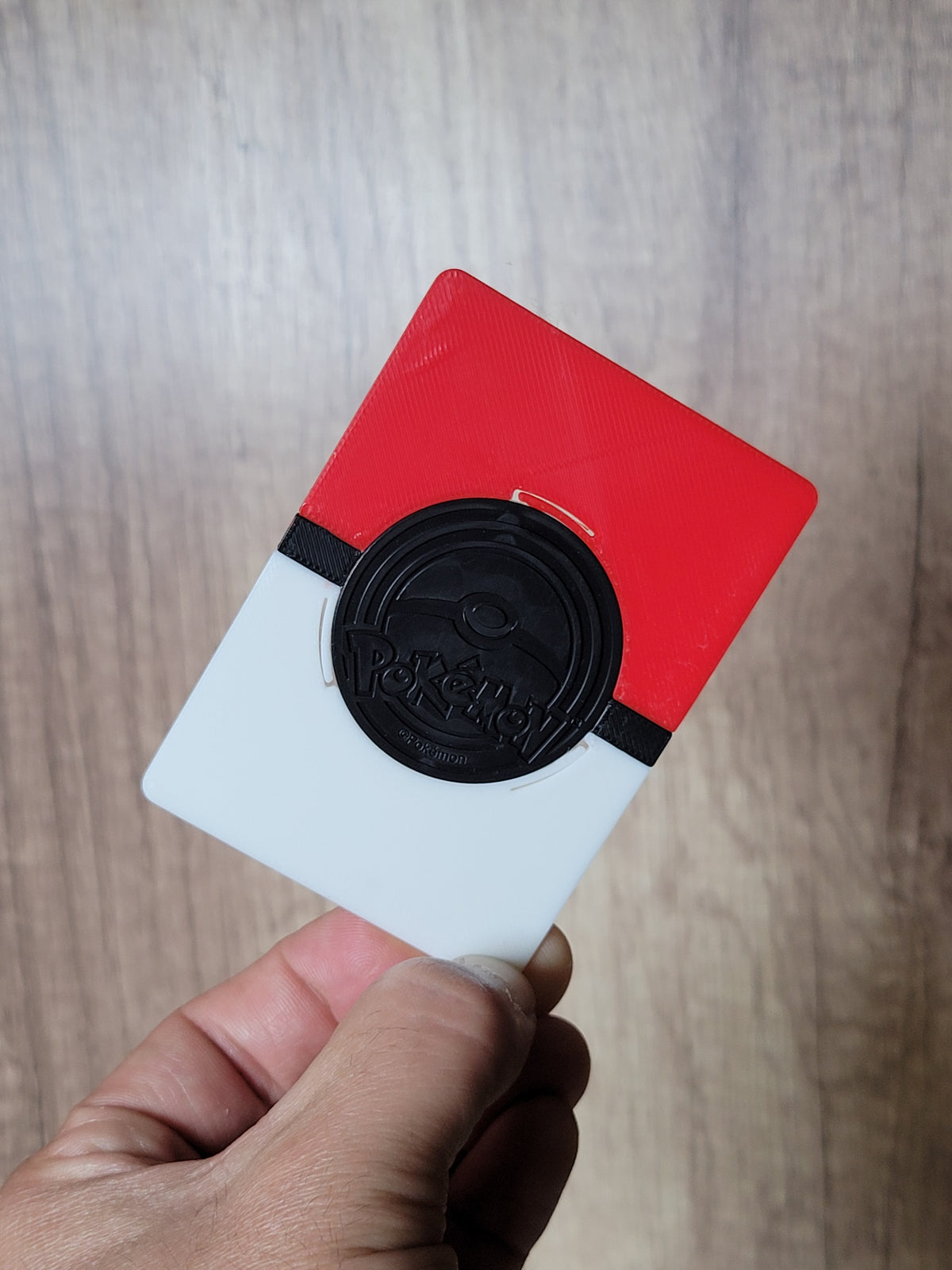 Reverse view of the coin display with the back of a dark Pokémon coin visible in its centered opening.