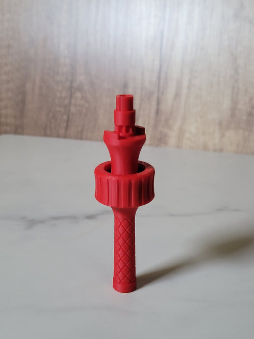 Red handheld Beyblade X balancing tool showing the textured handle, bearing grip and mounting peg.