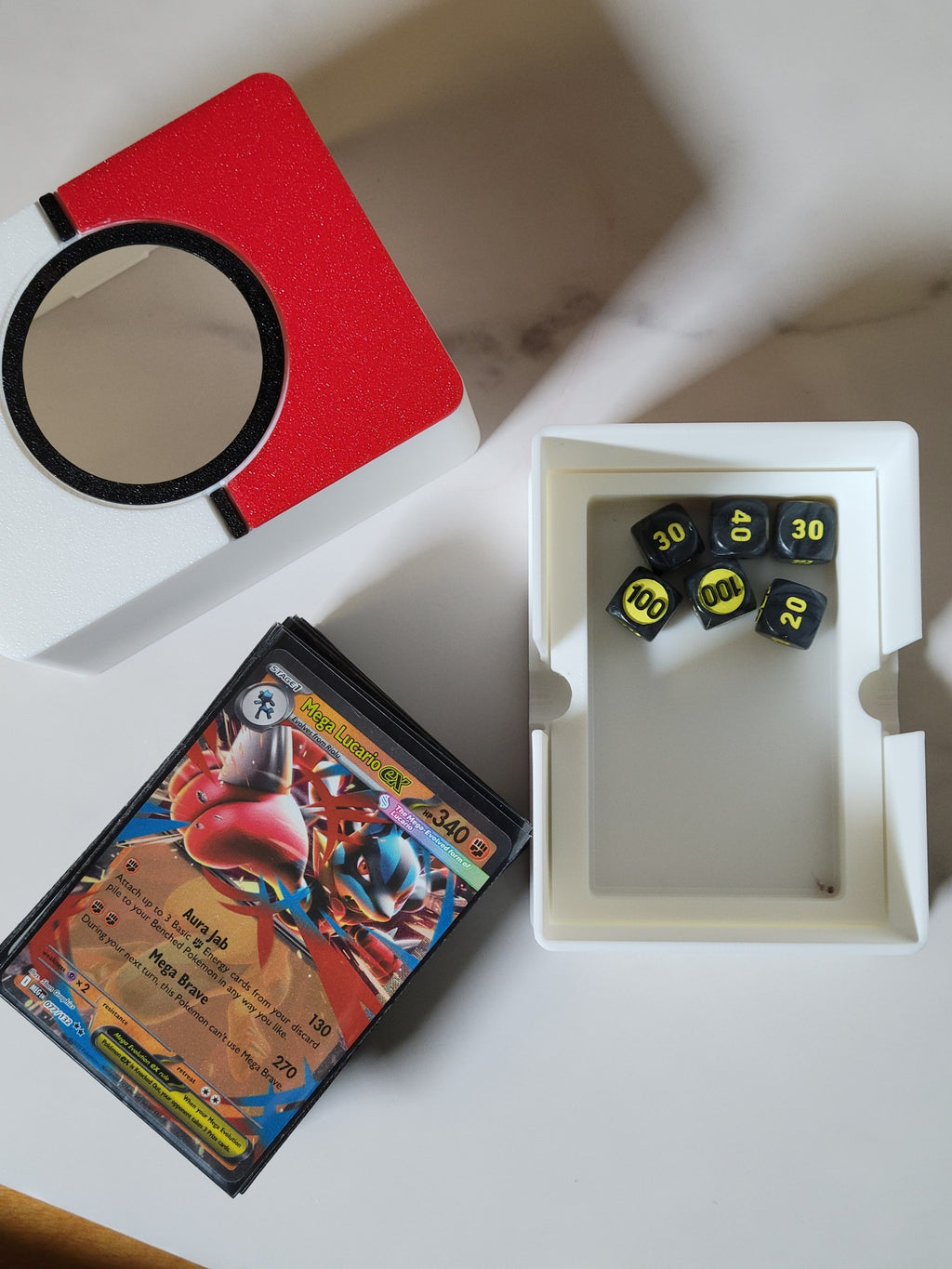 Open lower compartment holding small Pokémon damage-counter dice, with the sleeved deck removed.