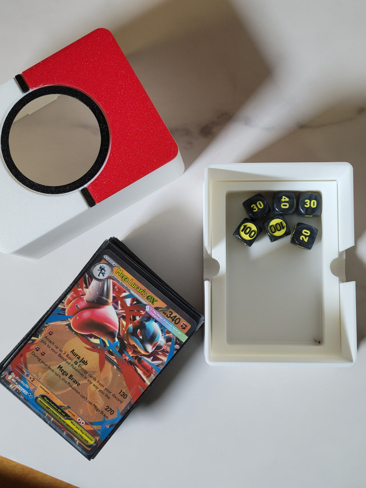 Open lower compartment holding small Pokémon damage-counter dice, with the sleeved deck removed.