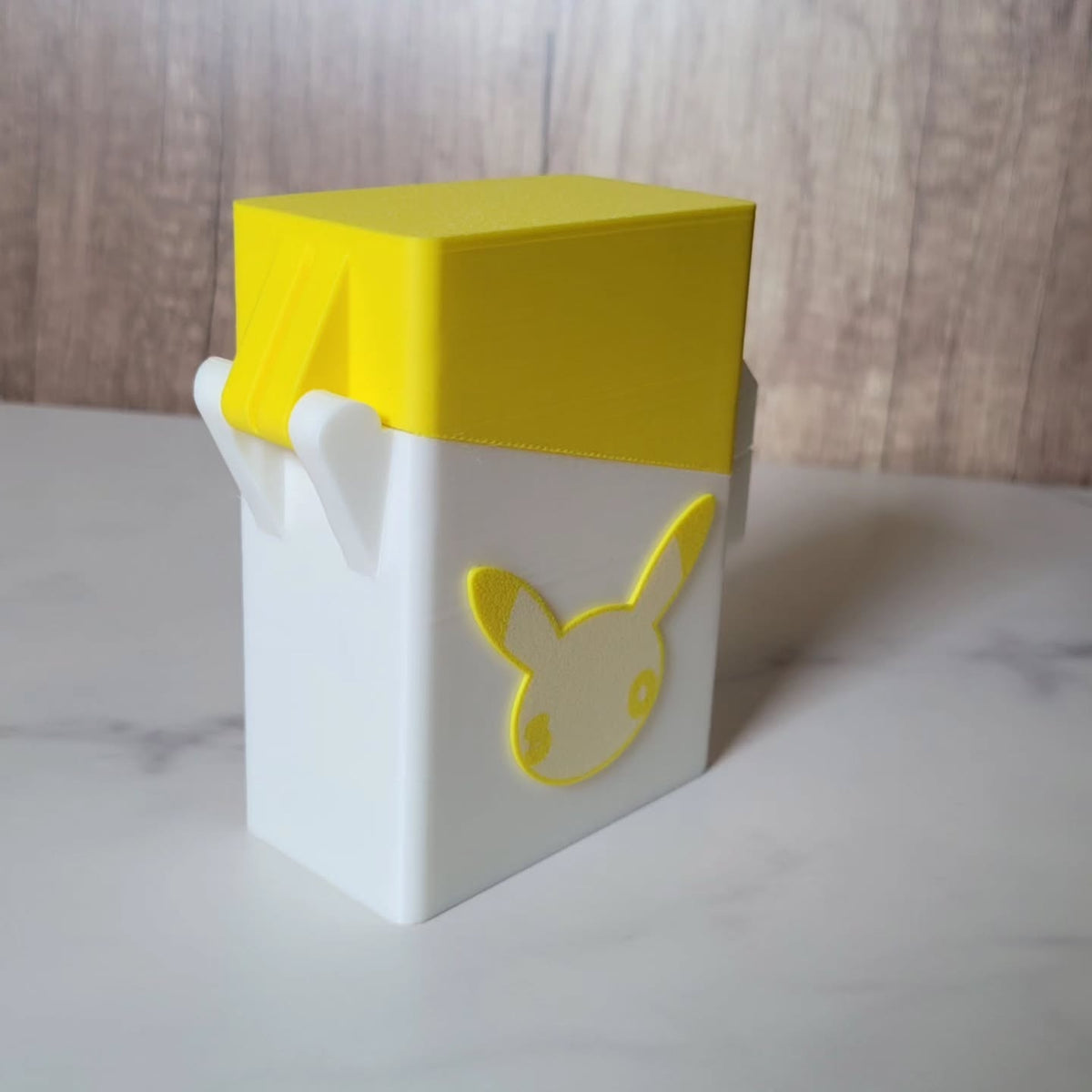 Angled rear view of the yellow deck box showing its lid and white accents.