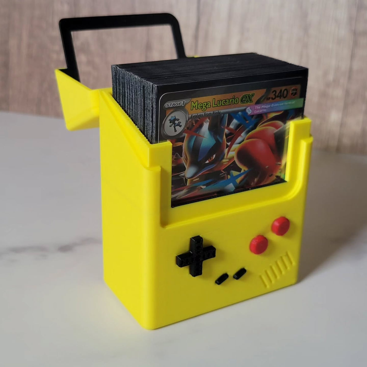 Front view of an open yellow Game Boy Color-inspired deck box holding sleeved trading cards.