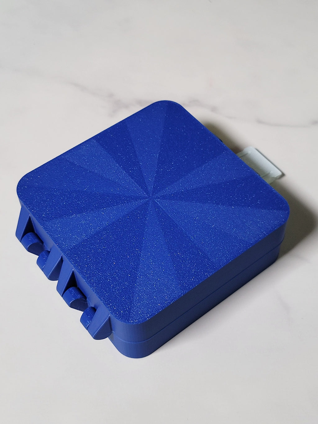 Underside of the blue Bit Box showing its textured geometric finish.