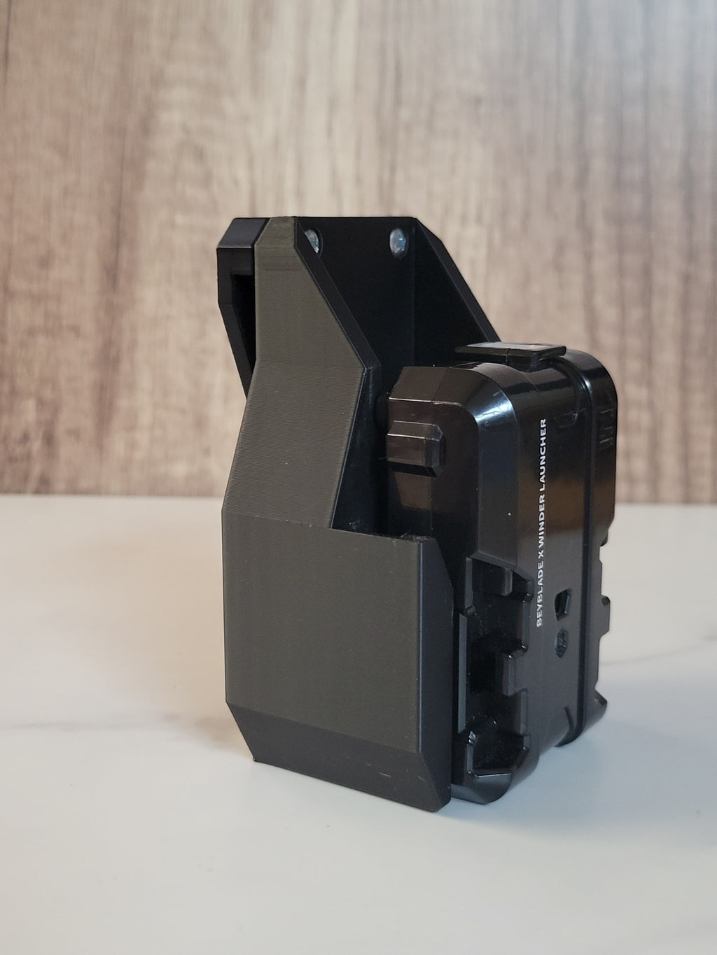 Black launcher mounted in a black holster.