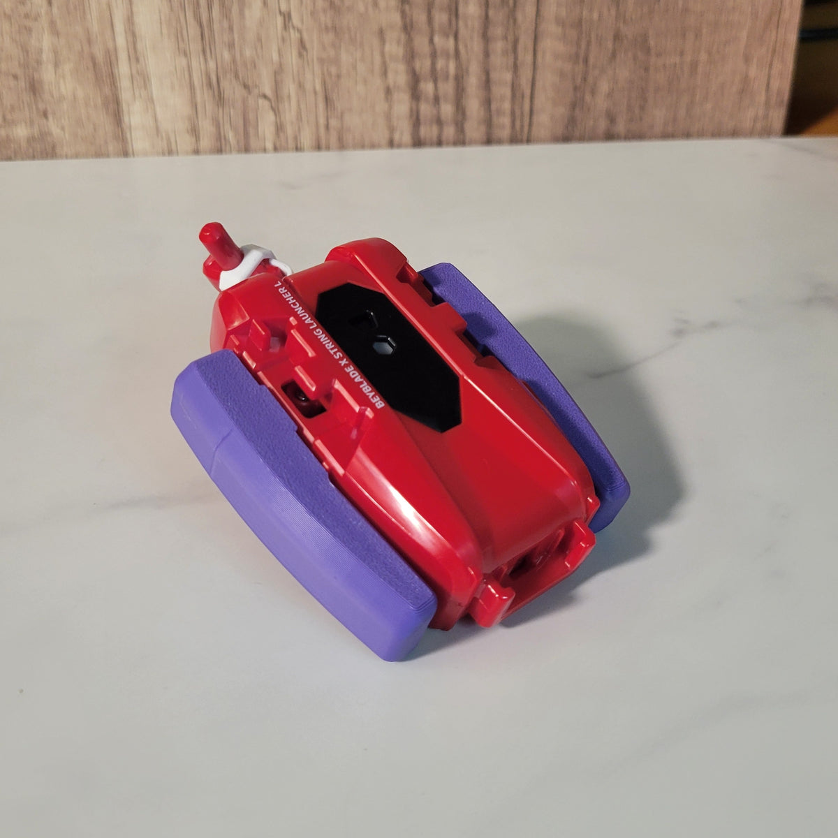 Angled side view of the purple string launcher grip.