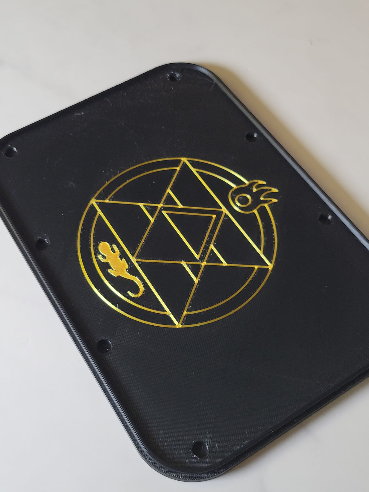 Inside of a black BSB magnetic lid showing gold original alchemy artwork and magnet recesses.