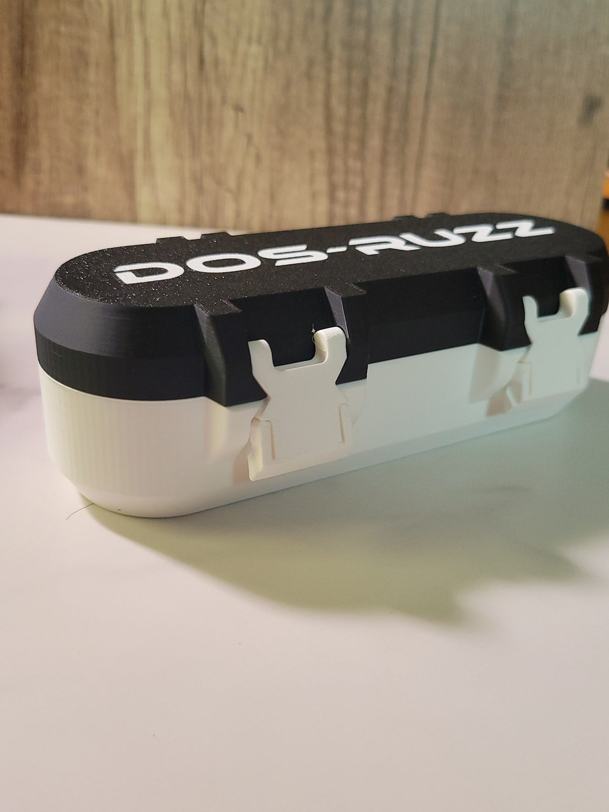 Closed black and white deck box showing its side and lid.