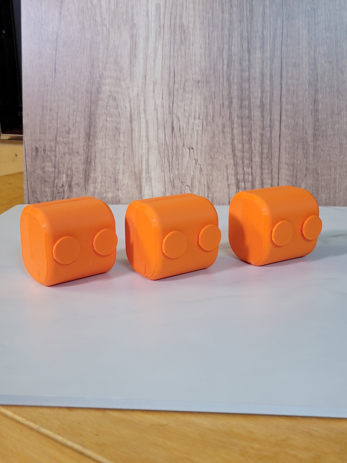 Rear view of three orange printed belt deck boxes.