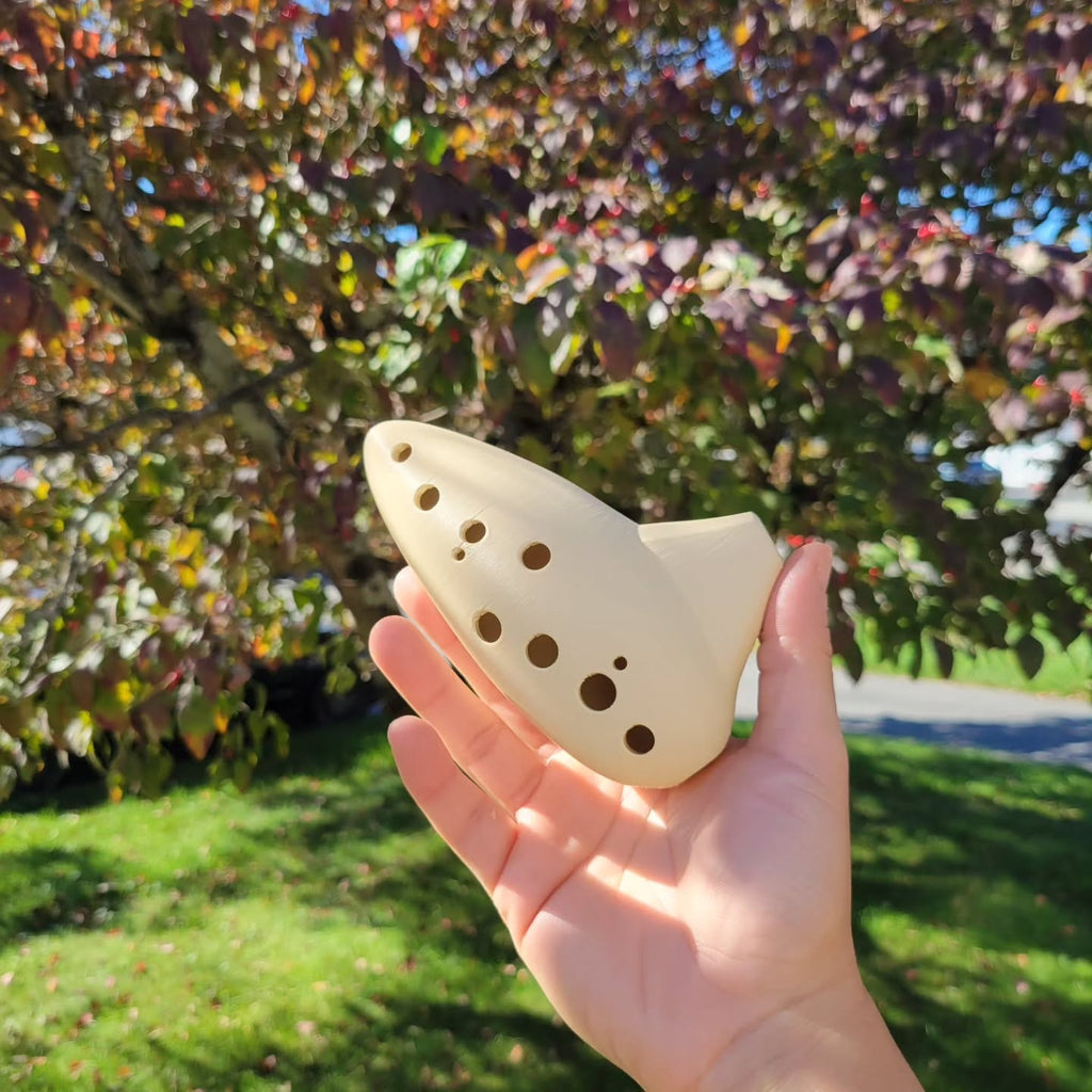 Light-colored playable 3D-printed ocarina held outdoors.