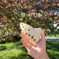 Light-colored playable 3D-printed ocarina held outdoors.