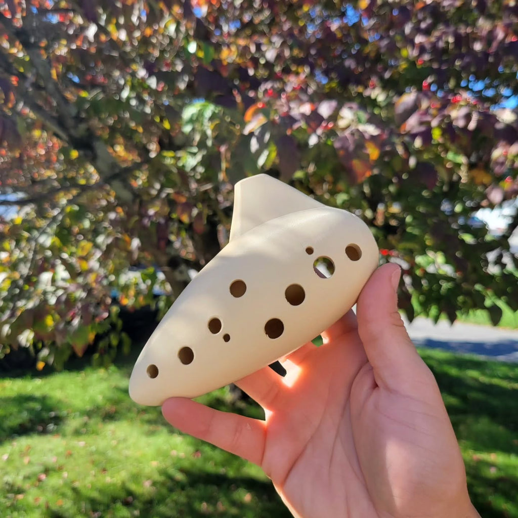 Side view of the 3D-printed ocarina showing finger holes and mouthpiece.