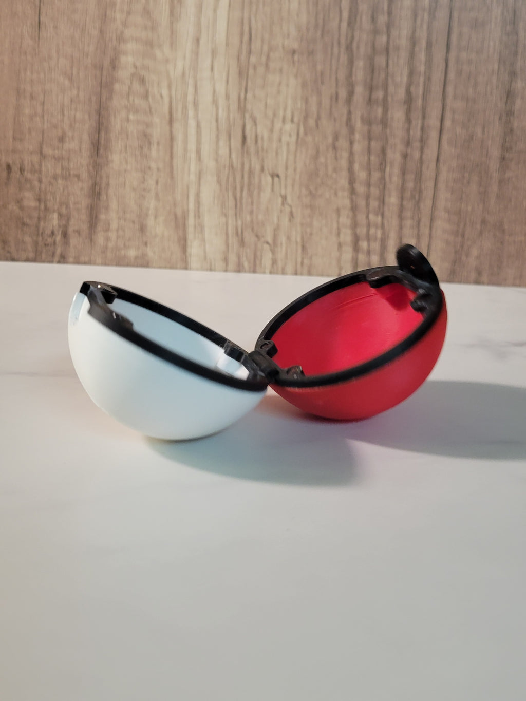 Open red and white Poke Ball inspired clamshell holder showing the interior