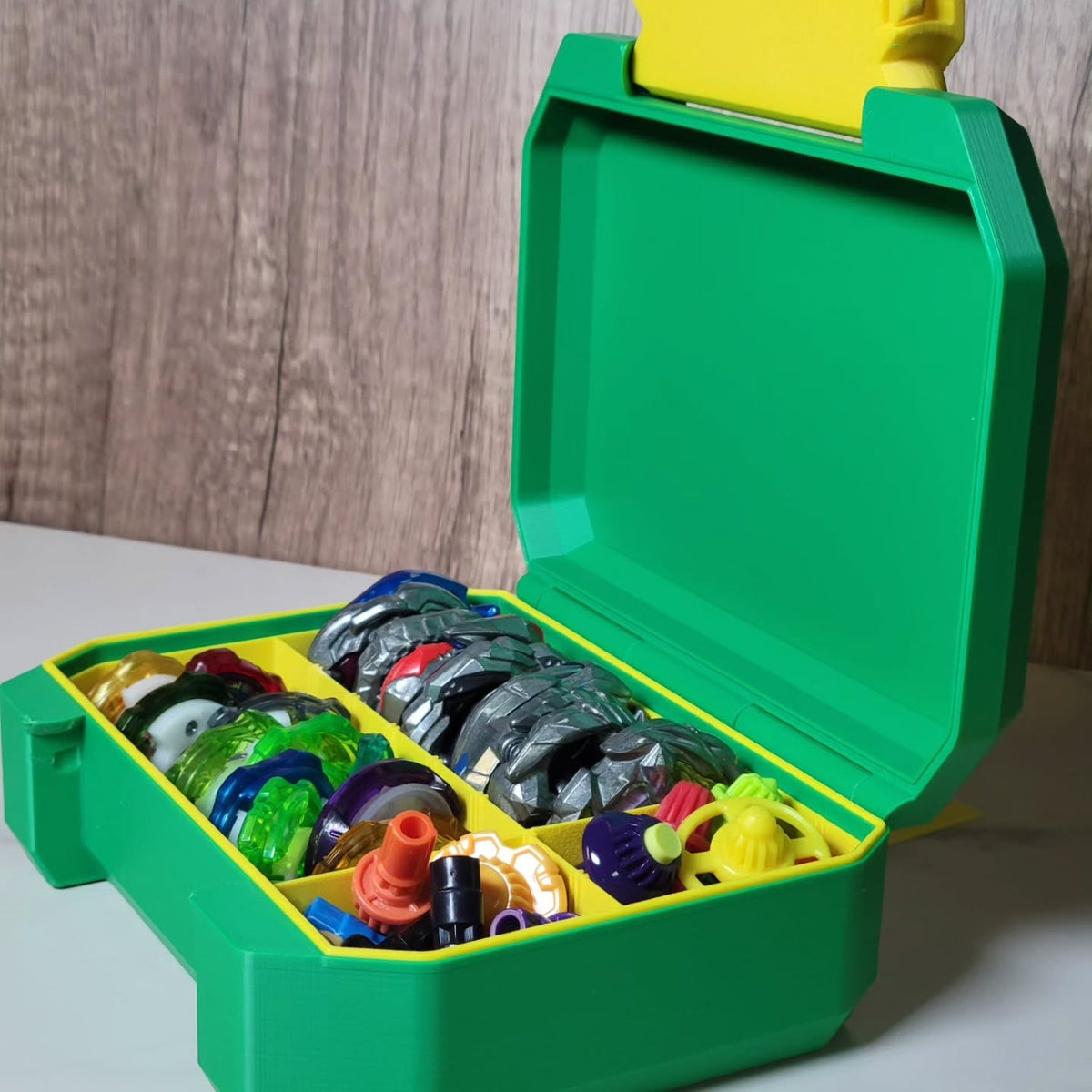 Open green and yellow Ratchet Box with Beyblade gear organized inside.
