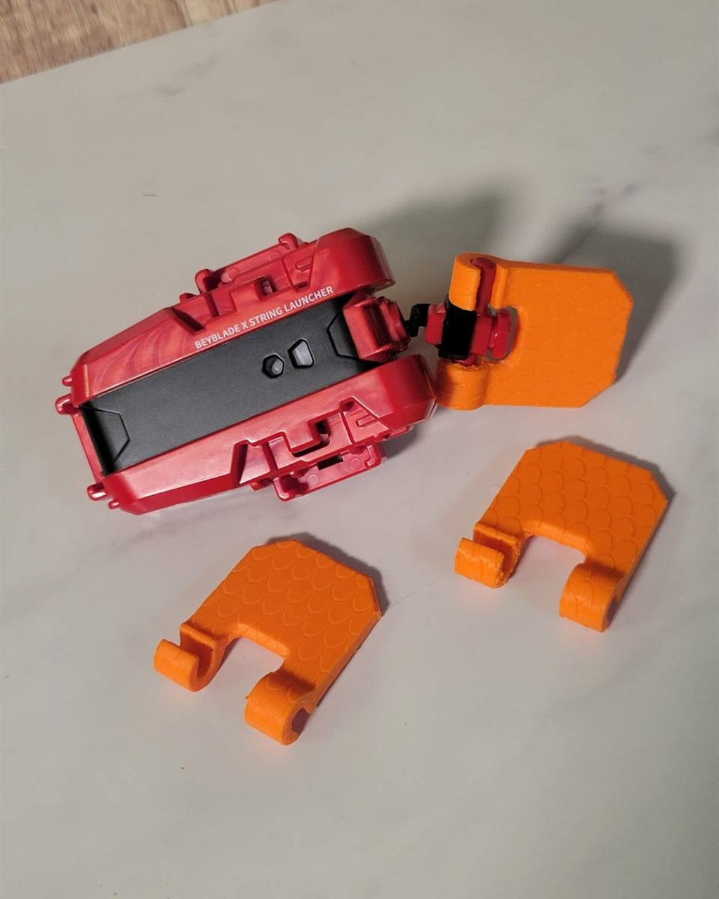 Orange large pull grip examples beside a launcher; launcher not included